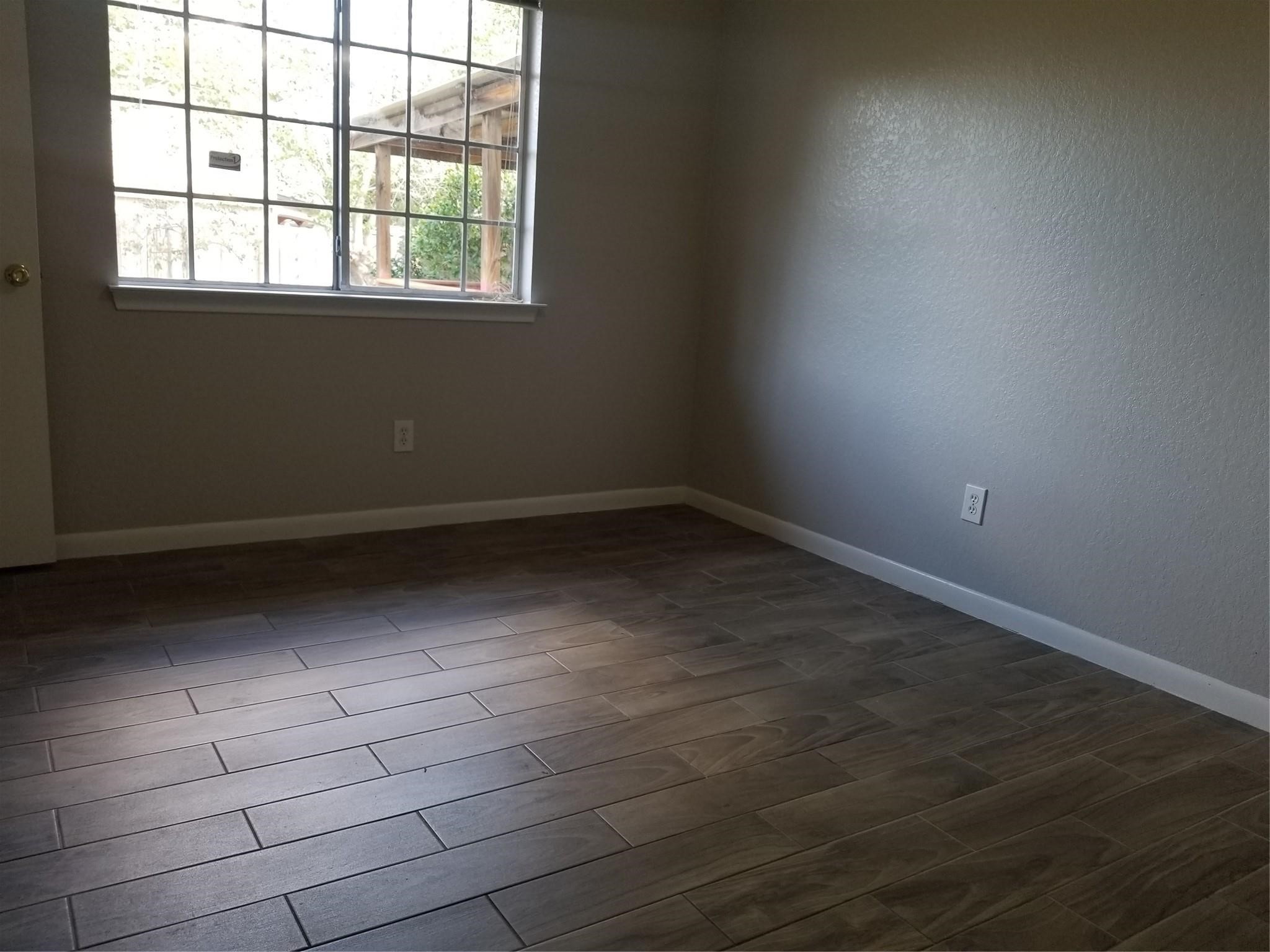 8331 Swiftwater Lane Houston, TX 77075 - Photo 12 of 14 wooden floor in an empty room with a window