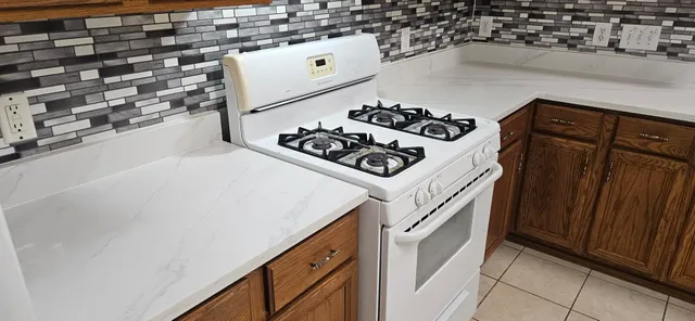 a kitchen with granite countertop white cabinets and white appliances
