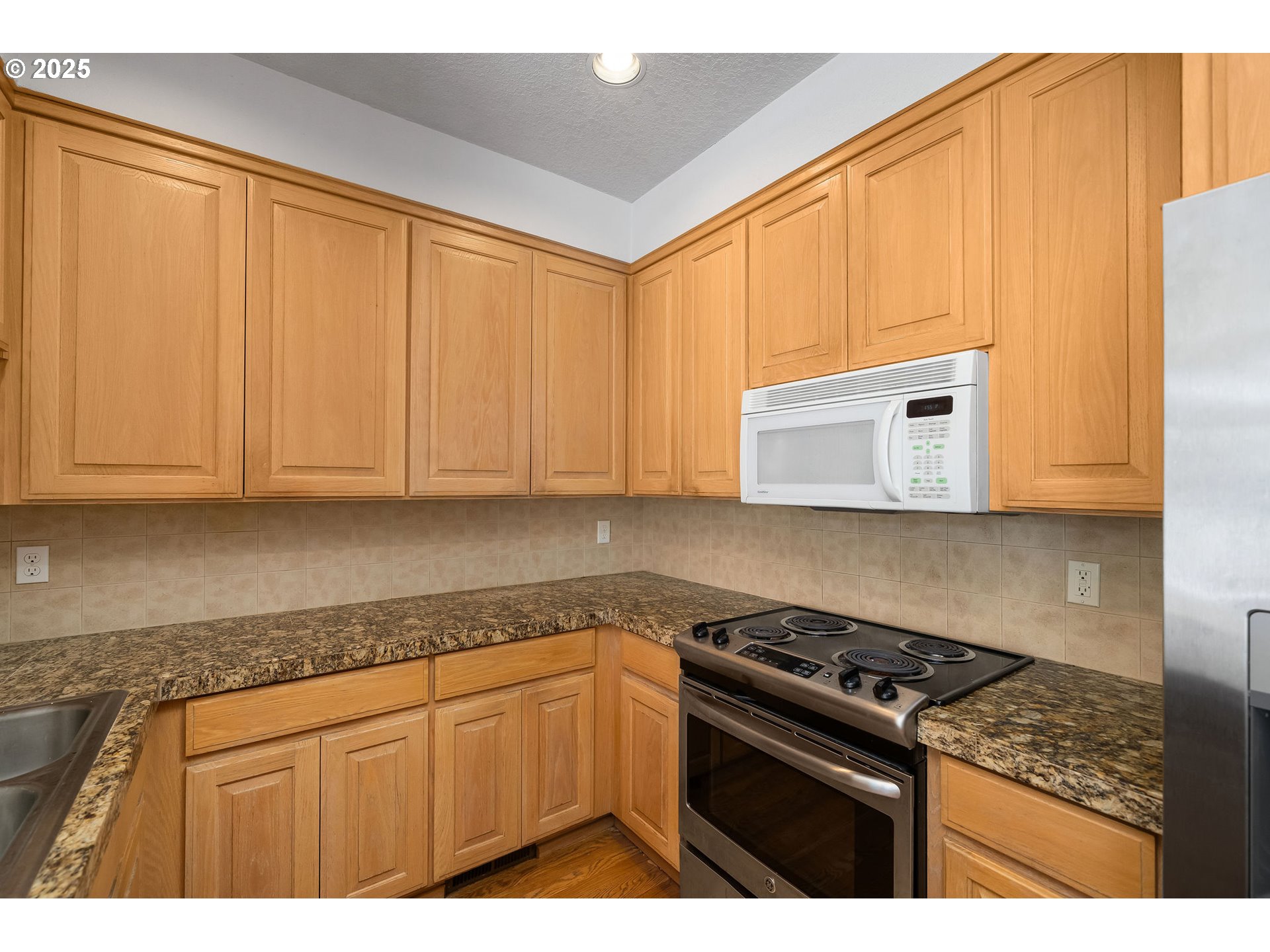 236 South Sweeney Street Portland, OR 97239 - Photo 9 of 29 a kitchen with granite countertop a stove a sink dishwasher and white cabinets
