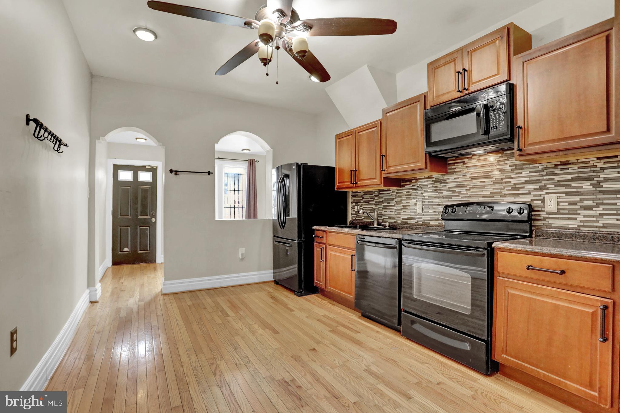 a kitchen with stainless steel appliances granite countertop a stove cabinets and wooden floor