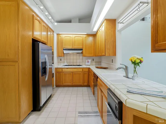 a kitchen with a sink a refrigerator and cabinets