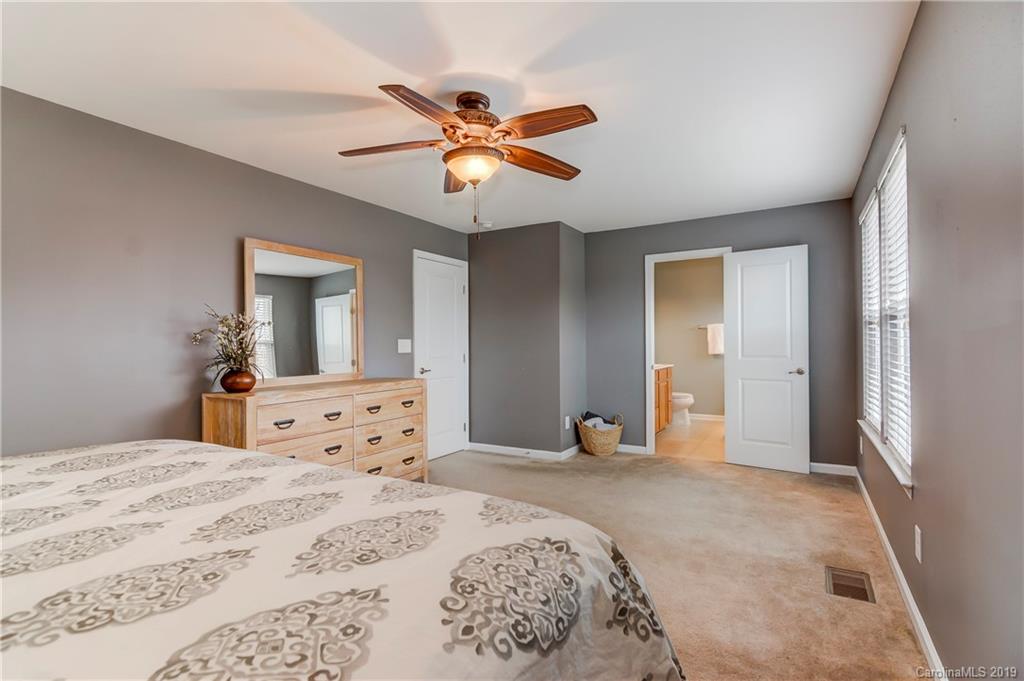7512 West Berkeley Road Denver, NC 28037 - Photo 22 of 32 a bedroom with a bed and a chandelier