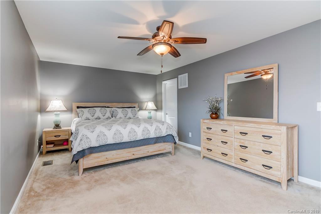 7512 West Berkeley Road Denver, NC 28037 - Photo 23 of 32 a bedroom with furniture and a flat tv screen on dresser