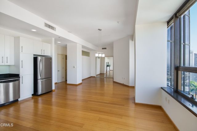 a view of an empty room with a window and wooden floor