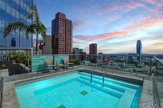 a swimming pool with outdoor seating and city view