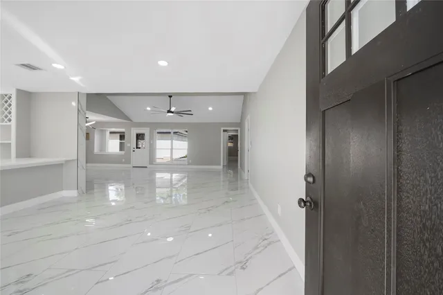 a hallway with white cabinets and chandelier
