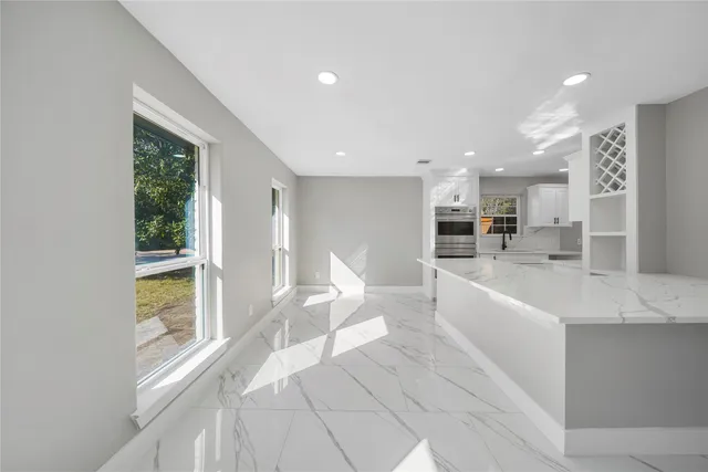 a large white kitchen with a large window