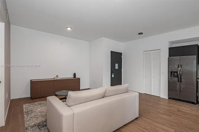 a living room with furniture and a refrigerator