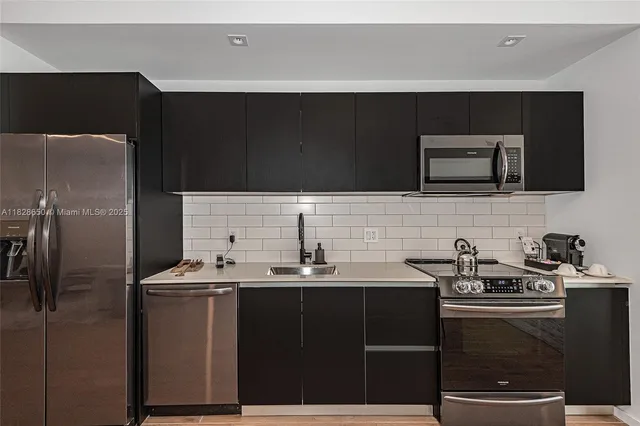 a kitchen with stainless steel appliances a sink stove and microwave