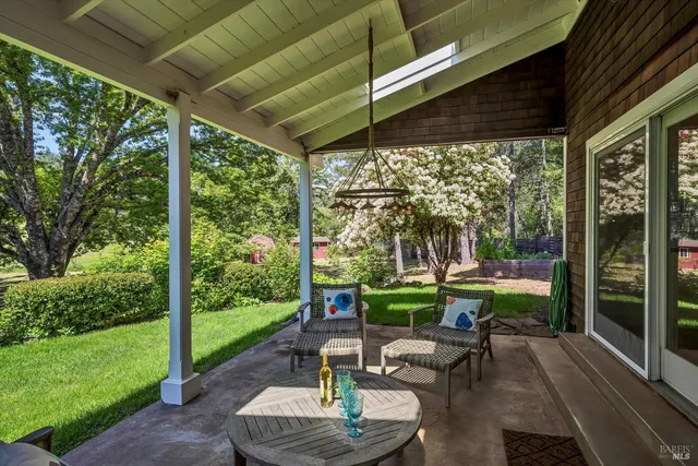 a view of a patio with table and chairs potted plants with floor to ceiling window