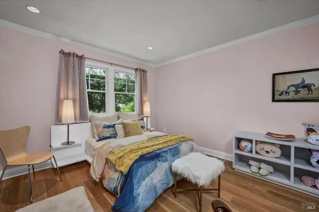 a bedroom with a bed a chair and a large window