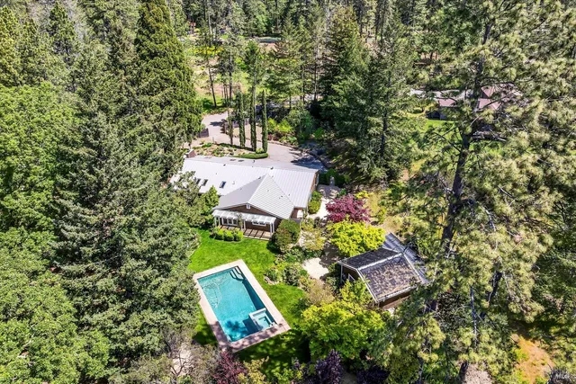 an aerial view of a house with a yard and lake view