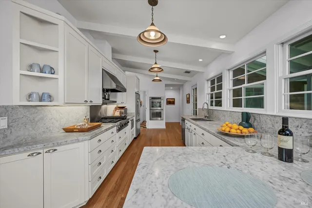 a kitchen that has a lot of cabinets and wooden floor