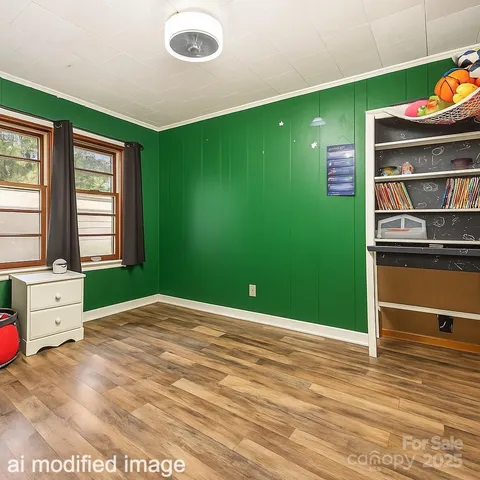 a view of an empty room with window and hardwood floor