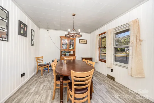 a dining room with furniture a chandelier and wooden floor