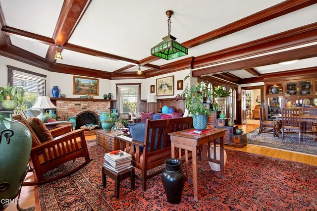 a living room with furniture fireplace and a large window