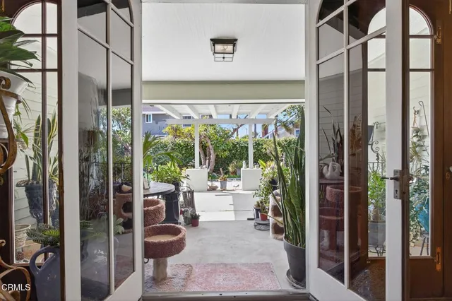 a view of a patio with table and chairs potted plants and large tree
