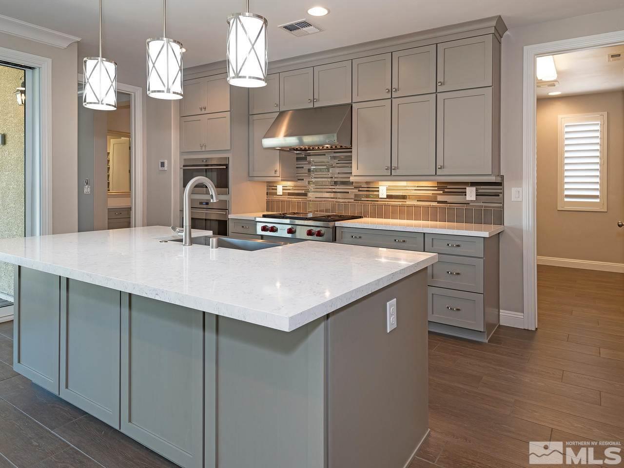 9875 Hafflinger Lane Reno, NV 89521 - Photo 6 of 39 a kitchen with kitchen island granite countertop a sink cabinets and stainless steel appliances