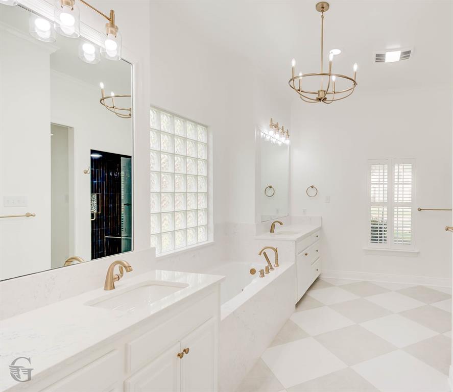 316 Autumn Ridge Drive Bossier City, LA 71111 - Photo 12 of 40 a bathroom with a tub a double vanity sink a window and mirror