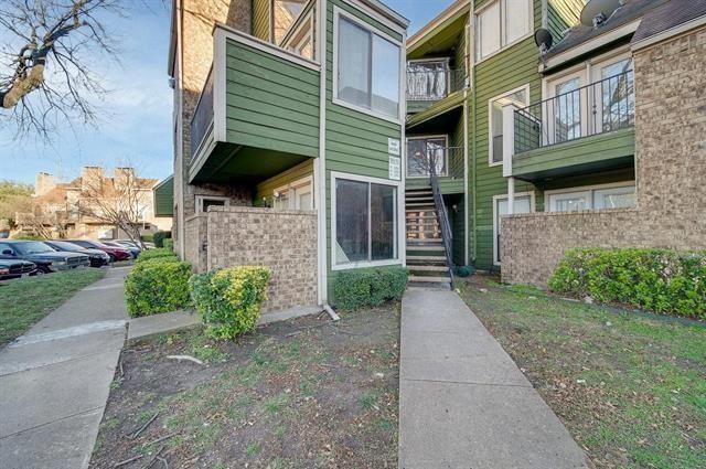 Multi-level exterior featuring green horizontal siding and brick accents