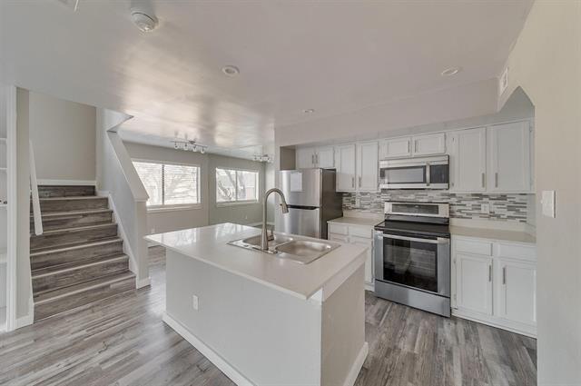 9815 Walnut Street, Unit 212 Dallas, TX 75243 - Photo 6 of 10 Kitchen featuring white cabinetry, light countertops, and stainless steel appliances