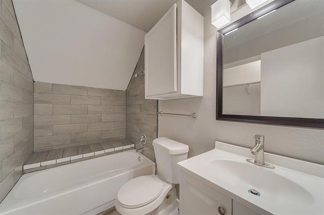 9815 Walnut Street, Unit 212 Dallas, TX 75243 - Photo 8 of 10 Bathroom featuring a white vanity with an integrated sink, brushed nickel faucet, and a framed mirror with overhead lighting