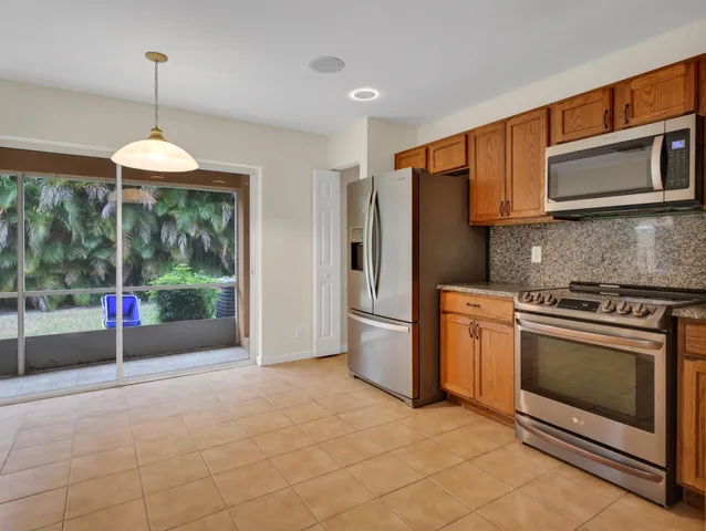 a kitchen with stainless steel appliances granite countertop a refrigerator stove and sink