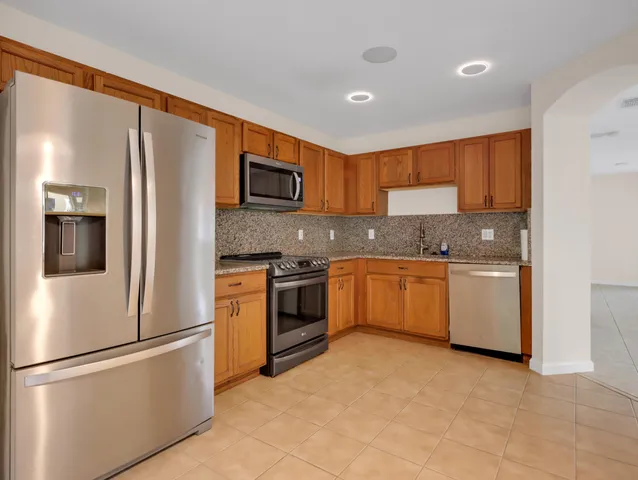 a view of an empty room with window and chandelier