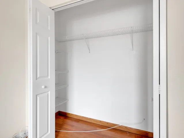 an empty room with wooden floor and entrance