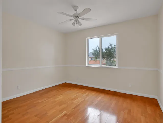 an empty room with a window and a ceiling fan
