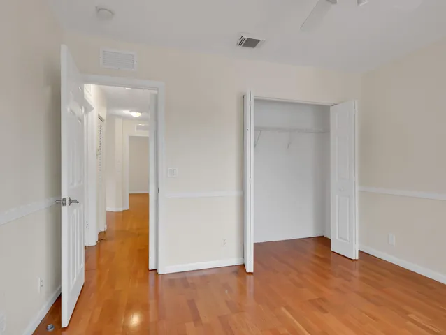 a view of an empty room with chandelier fan