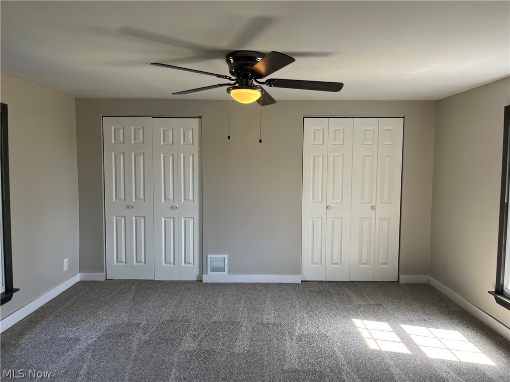 7255 Bagley Road Mount Perry, OH 43760 - Photo 16 of 29 Unfurnished bedroom featuring ceiling fan, carpet floors, and multiple closets