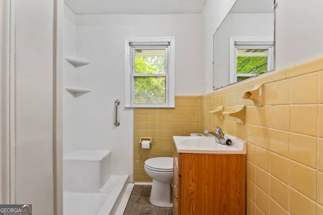 a kitchen with granite countertop white cabinets and window