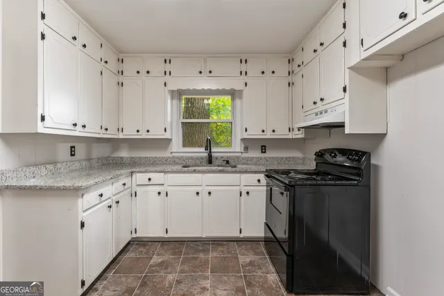 en empty room with wooden floor and windows