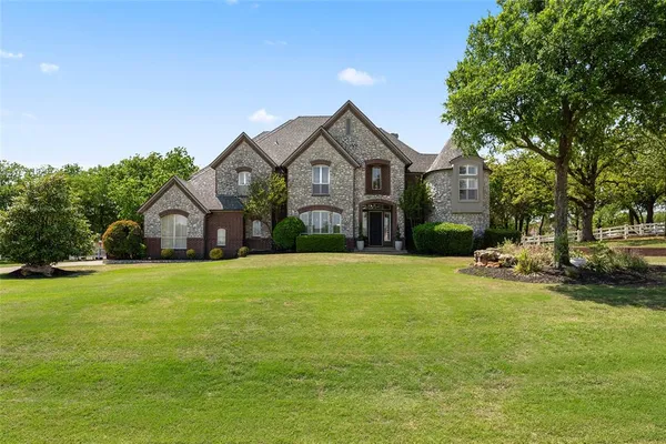 a front view of a house with yard and green space