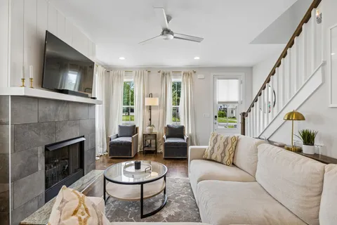 a living room with furniture a flat screen tv and a fireplace