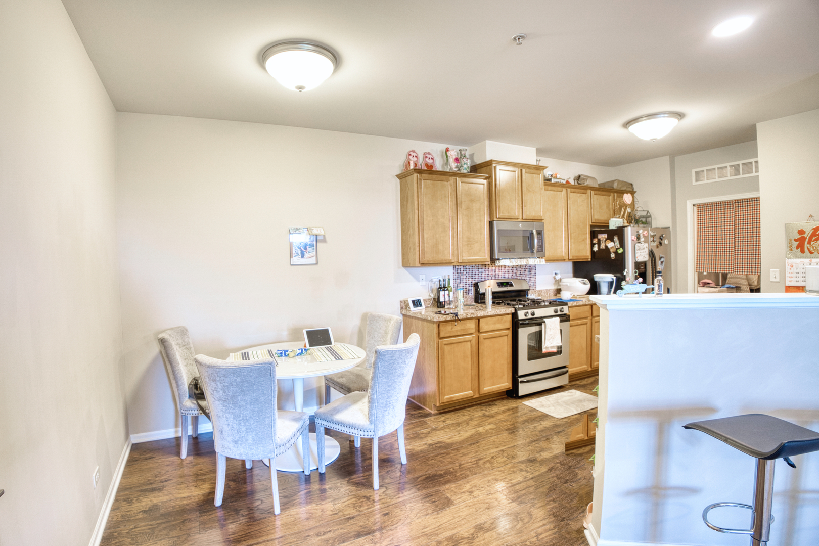 7520 Claridge Drive, Unit H Bridgeview, IL 60455 - Photo 9 of 22 a kitchen with a dining table chairs and white cabinets