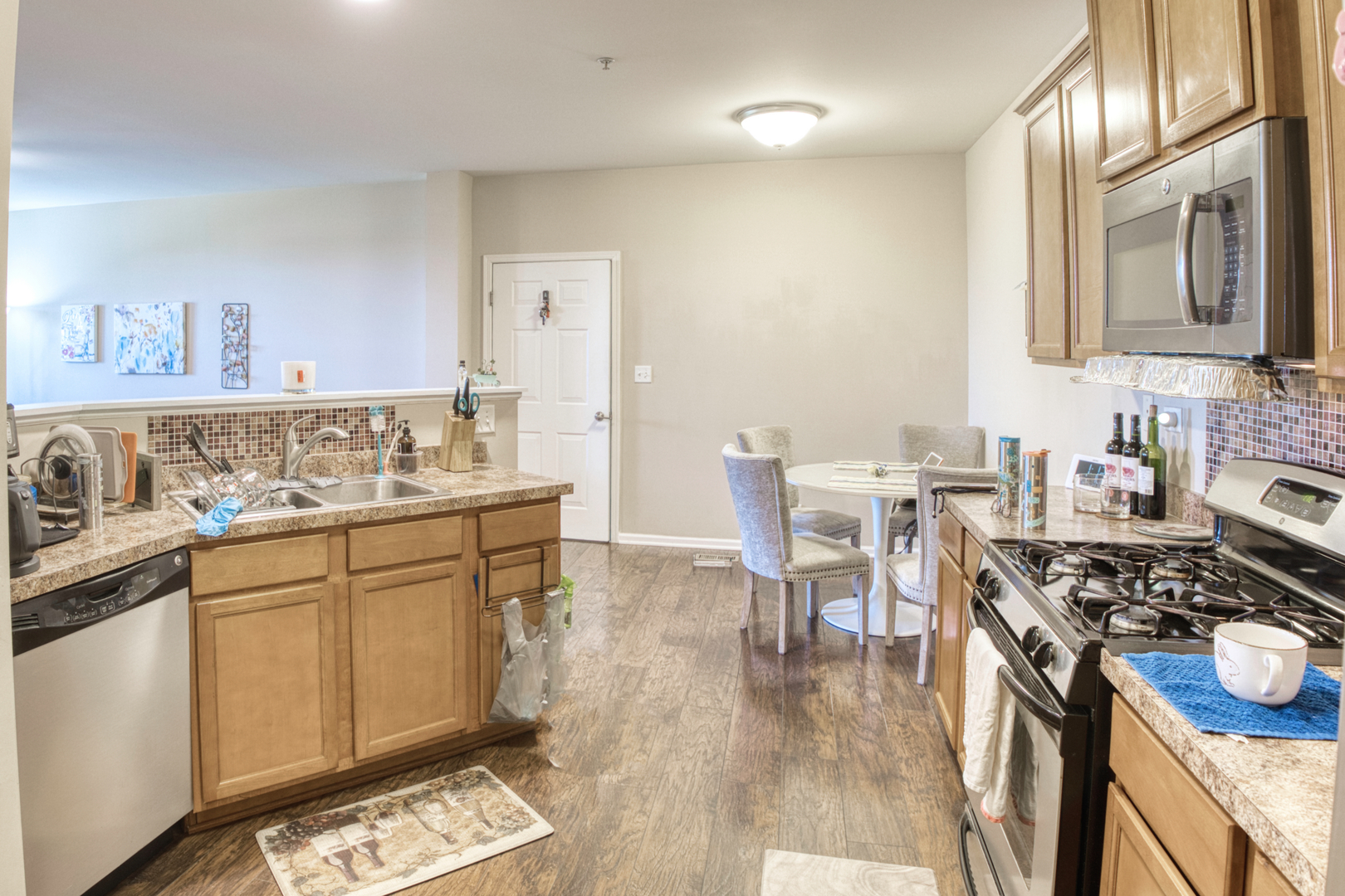 7520 Claridge Drive, Unit H Bridgeview, IL 60455 - Photo 10 of 22 a kitchen with stainless steel appliances a stove a sink dishwasher and cabinets with wooden floor