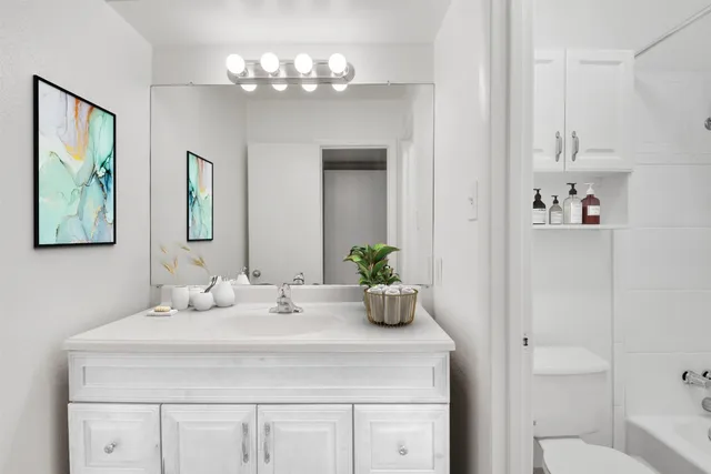 a bathroom with a sink a large mirror and a toilet