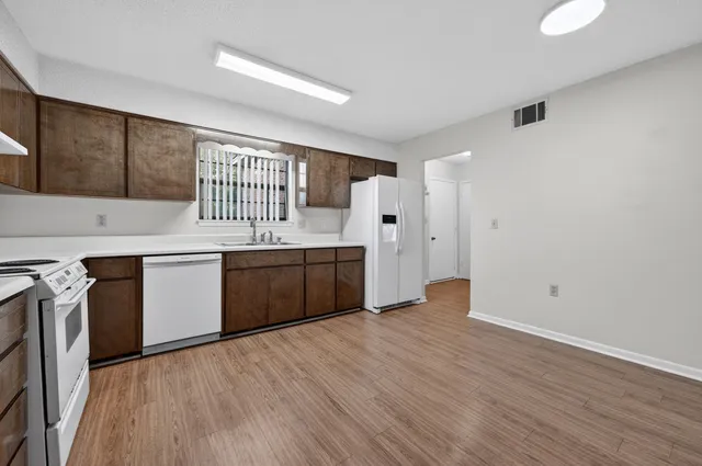 a kitchen with a sink cabinets and wooden floor