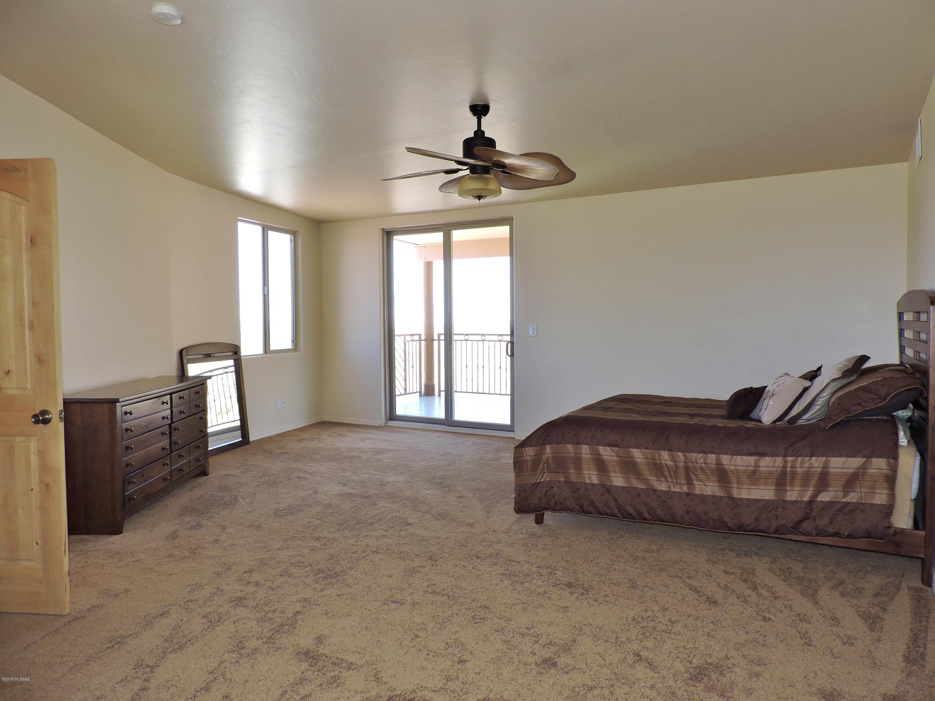 1716 Ave Calamar Rio Rico, AZ 85648 - Photo 21 of 36 a living room with a bed furniture a chandelier and closet