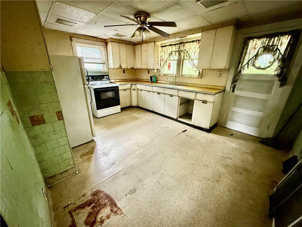 411 East Avenue Allison, PA 15413 - Photo 8 of 19 a kitchen with stainless steel appliances granite countertop a sink a stove and a refrigerator