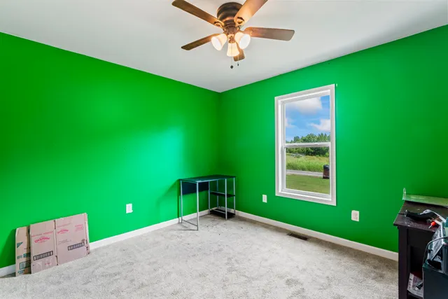 a view of a livingroom with a fan and window