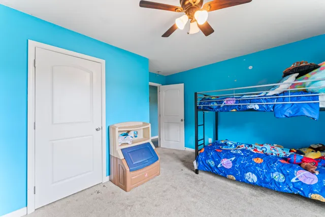 a bedroom with furniture and a fan