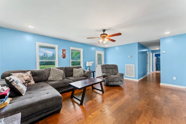 a living room with furniture and a ceiling fan