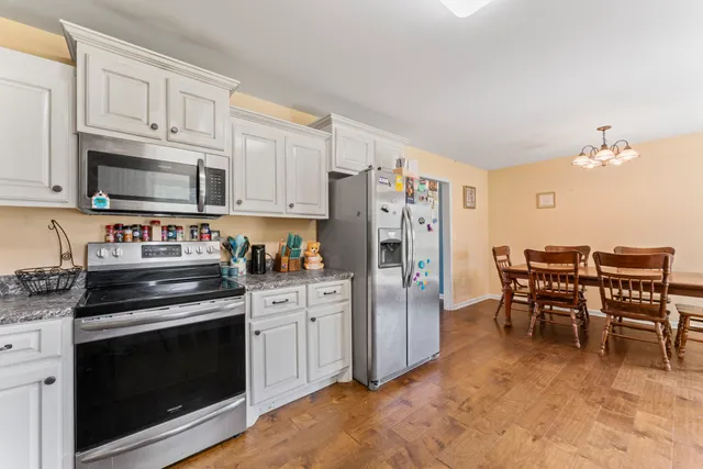 a kitchen with stainless steel appliances a stove a sink refrigerator and a cabinets