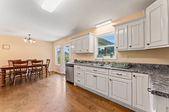 a kitchen with granite countertop white cabinets dining table and chairs