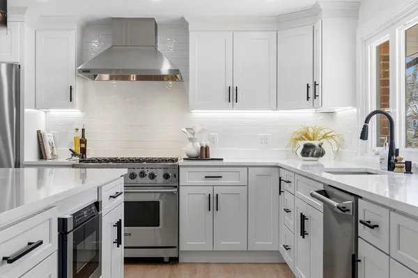 a kitchen with white cabinets stainless steel appliances and sink