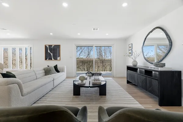 a living room with furniture a wooden floor and a chandelier