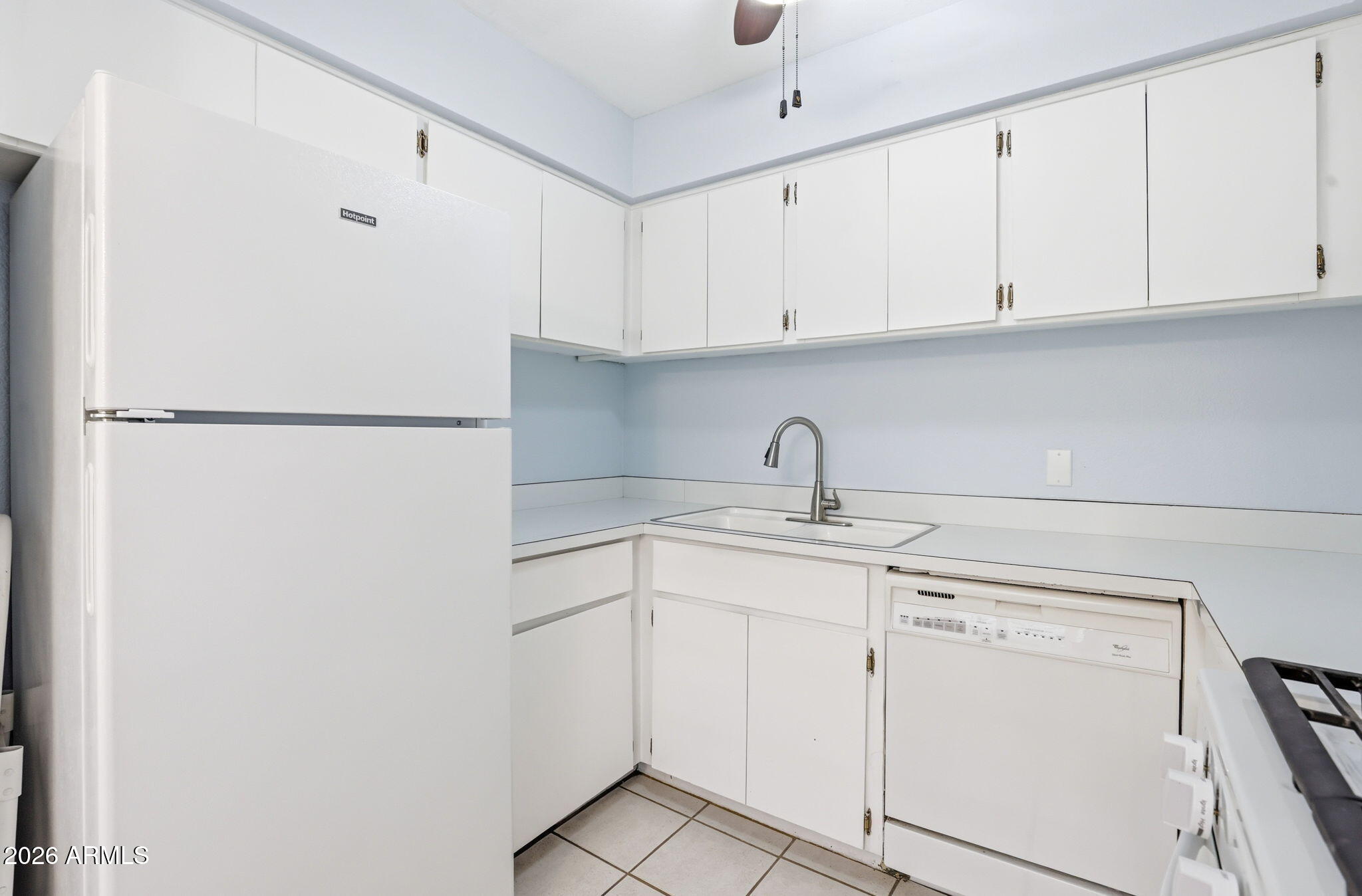 4950 North Miller Road, Unit 339 Scottsdale, AZ 85251 - Photo 16 of 28 a kitchen with white cabinets and white appliances